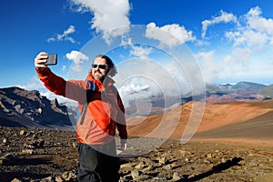 Tourist taking a photo of himself in Haleakala volcano crater on the Sliding Sands trail. Maui, Hawaii, USA.