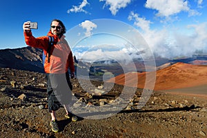Tourist taking a photo of himself in Haleakala volcano crater on the Sliding Sands trail. Maui, Hawaii, USA.