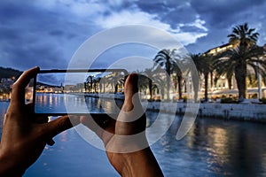 Tourist taking photo of promenade and sea in old town in Split, Croatia, Dalmatia, Europe