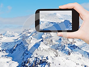 Tourist taking photo of snow mountains in Alpes photo