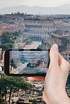 Tourist taking photo of street to Coliseum, Rome