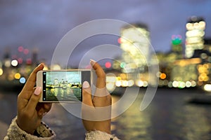 Tourist taking photo, Tower Bridge, London, with mobile phone