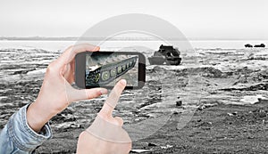 Tourist taking photo tracked vehicle on ice road