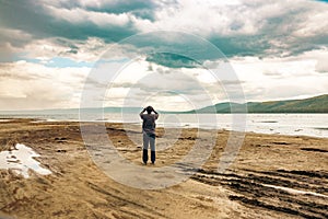 A tourist taking photos with a mobile phone at the shores of Lake Nakuru in Kenya