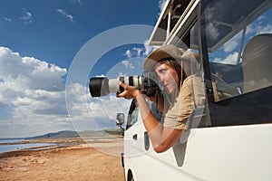 Tourist taking photos from the open window of jeep