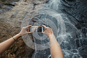 Tourist Taking Photos Of Waterfall With Mobile Phone. Travel Adventure Destination Outdoor Concept