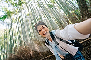 Tourist taking selfie in the bamboo grove