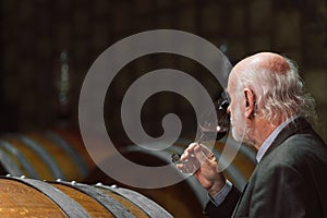 Tourist tasting red wine in an underground wine cellar