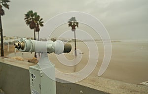 Tourist telescope placed on the beach to watch the boats