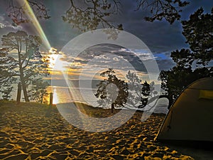 Tourist tent on the lake. Tourist tent at sunset. Tourist tent in nature.