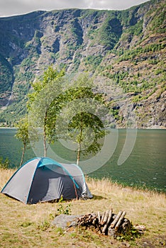 tourist tent and stack of firewood in camping near beautiful Aurlandsfjord Flam