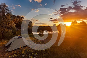 Tourist tents at riverbank in forest in summer morning photo