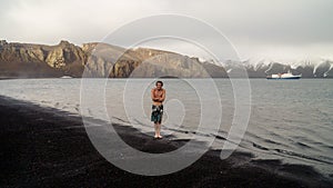 Tourist about to swim in freezing cold water on Deception Island in Antarctica.