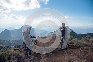 Tourist on top of mountain with message `Peak of Doi Laung Chiangdao`