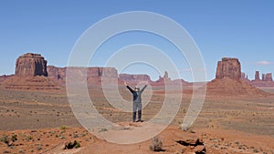 Tourist At Top And Raises Her Arms Up Celebrating Victory In Monument Valley Usa