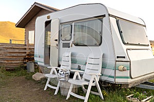 Tourist trailer is parked for recreation. White caravan trailer in camping site. recreational vehicle RV.