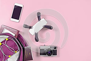 Tourist travel gadgets and objects in Backpack on pink