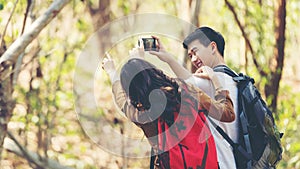 Tourist and traveler asian couple backpack enjoy happy take a photo selfie in the jungle forest nature park