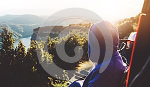 Tourist traveler on background top mountain sits and enjoys the sunset, hiker looking on blue sky clouds, nature panoramic land