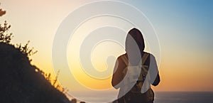 Tourist traveler with backpack on morning relax time, hiker looking on sunset to valley in trip, hipster young girl enjoying peak