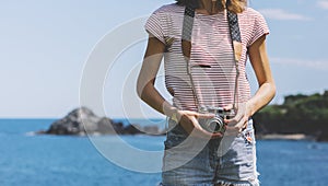 Tourist traveler photographer making pictures seascape on vintage photo camera on background yacht and boat piar,