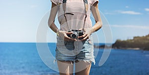 Tourist traveler photographer making pictures seascape on vintage photo camera on background yacht and boat piar, hipster girl