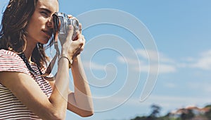 Tourist traveler photographer making pictures seascape on vintage photo camera on background yacht and boat piar, hipster girl enj