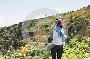 Tourist traveler photographer taking pictures of amazing landscape on vintage photo camera on background valley view mockup sun