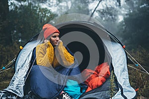 Tourist traveler ralaxing in camp tent in foggy rain forest, closeup happy hiker woman enjoy mist nature trip, green trekking