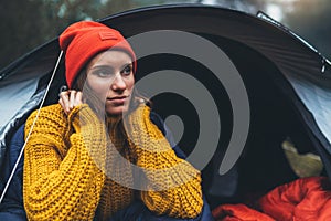 Tourist traveler ralaxing in camp tent in froggy mist forest, portrait lonely hiker woman enjoy nature trip, green trekking