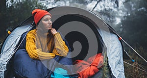 Tourist traveler ralaxing in camp tent in froggy rain forest, hiker woman enjoy mist nature trip, green trekking tourism, rest photo