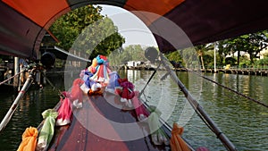 Tourist trip on Asian canal. View of calm channel and residential houses from decorated traditional Thai boat during tourist trip