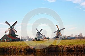 Tourist trip to Zaanse schans on a sunny day, among the typical and characteristic windmills of Holland and its waterways
