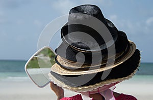 Tourist trying on Bahama hats.