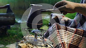 A tourist turns on a portable gas stove for boiling water in a Turk.