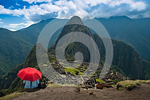 Tourist under red umbrella at Machu Picchu