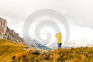 The tourist uses her smartphone to capture the scenic Alpine mountain meadows