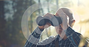 Tourist using binoculars and observing wildlife