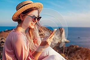 Tourist using smartphone on Aegean sea background on Santorini island, Greece. Woman traveling. Summer vacation