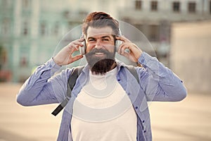 Tourist vacation. Hipster modern tourist urban background. Tourist handsome hipster with backpack headphones. Man with