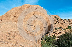 Tourist is visible on rocks above cave at Bushmans Paradise