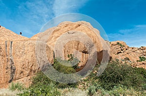 Tourist is visible on rocks above cave at Bushmans Paradise