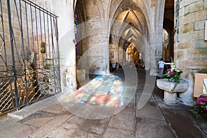 Tourist visit the Basilica de Saint-Saveur in Dinan with reflections of stained glass windows on the stone floor