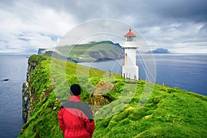 Tourist visiting the landmark of Mykines Island - Holmur Lighthouse