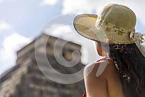 Tourist visiting the pyramid of Chichen Itza in honor of the God Kukulkan the feathered serpent under a beautiful tropical blue