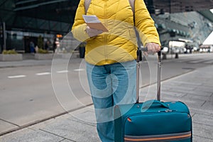Tourist is waiting a taxi. Senior woman stand outside airport and wait for taxi cab after vacation or travel.