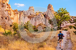 Tourist walking along cave rocks in Cappadocia