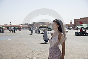 Tourist walking and enjoying the Jmaa El Fna square, which is the main square in Marrakech
