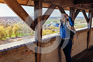 Tourist walking on Olesko Castle balcony admiring spring landscape wearing mask during coronavirus covid-19 pandemic.