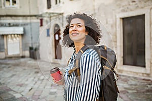 Tourist walking on the street in european old city drink coffee